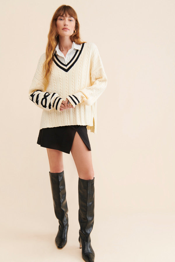 oversized v neck sweater, exaggerated long sleeve, cream cable knit, cream color with black accents, high-low hem length