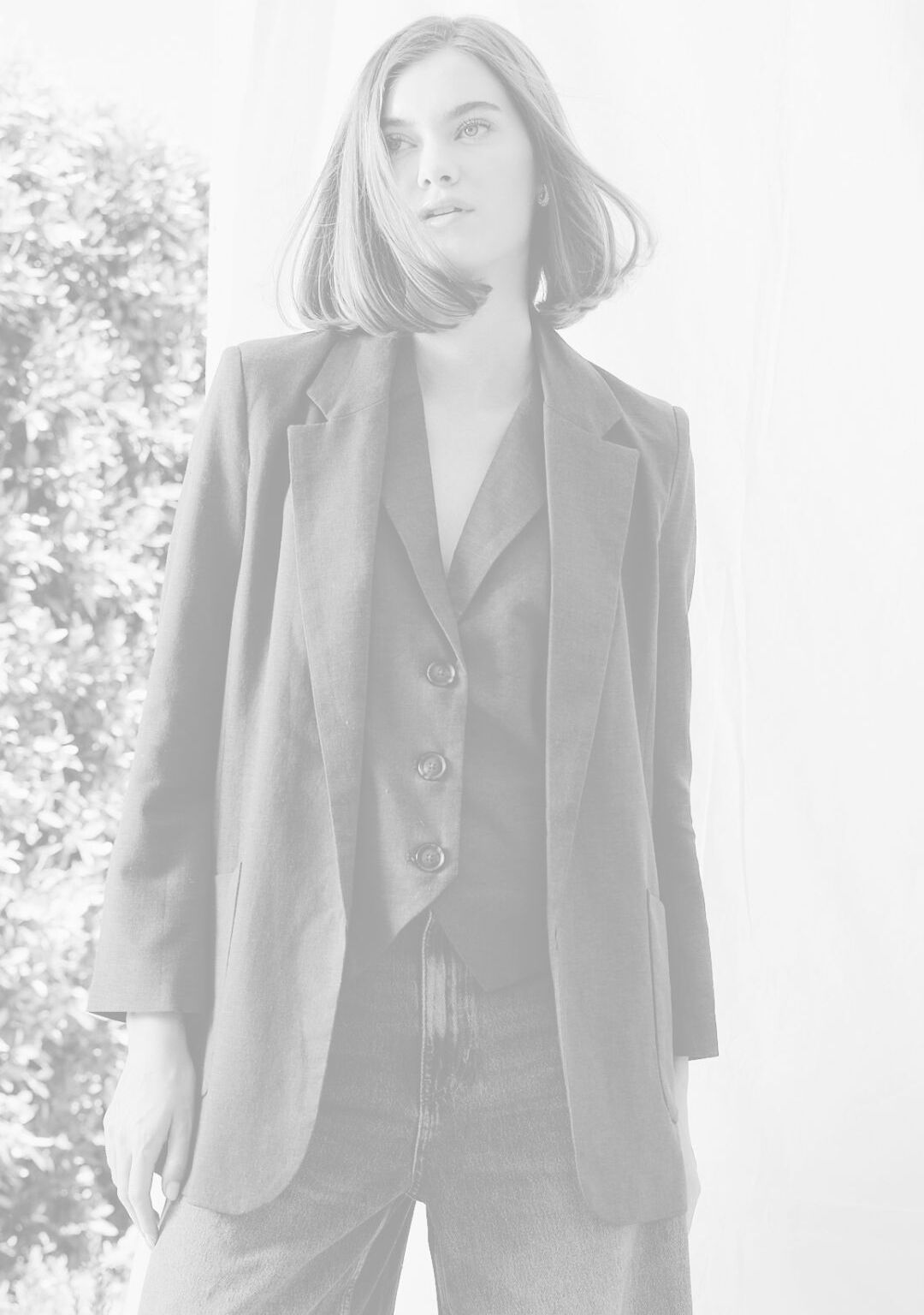 Person wearing a suit standing outdoors with trees in the background